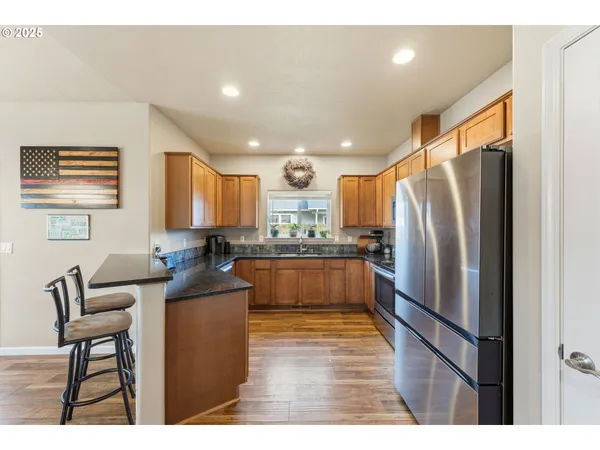 a kitchen with stainless steel appliances granite countertop a refrigerator and a stove top oven