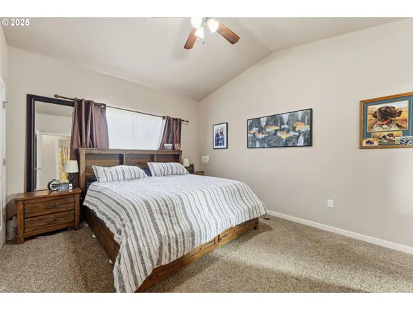 a bedroom with a bed and a painting on the wall