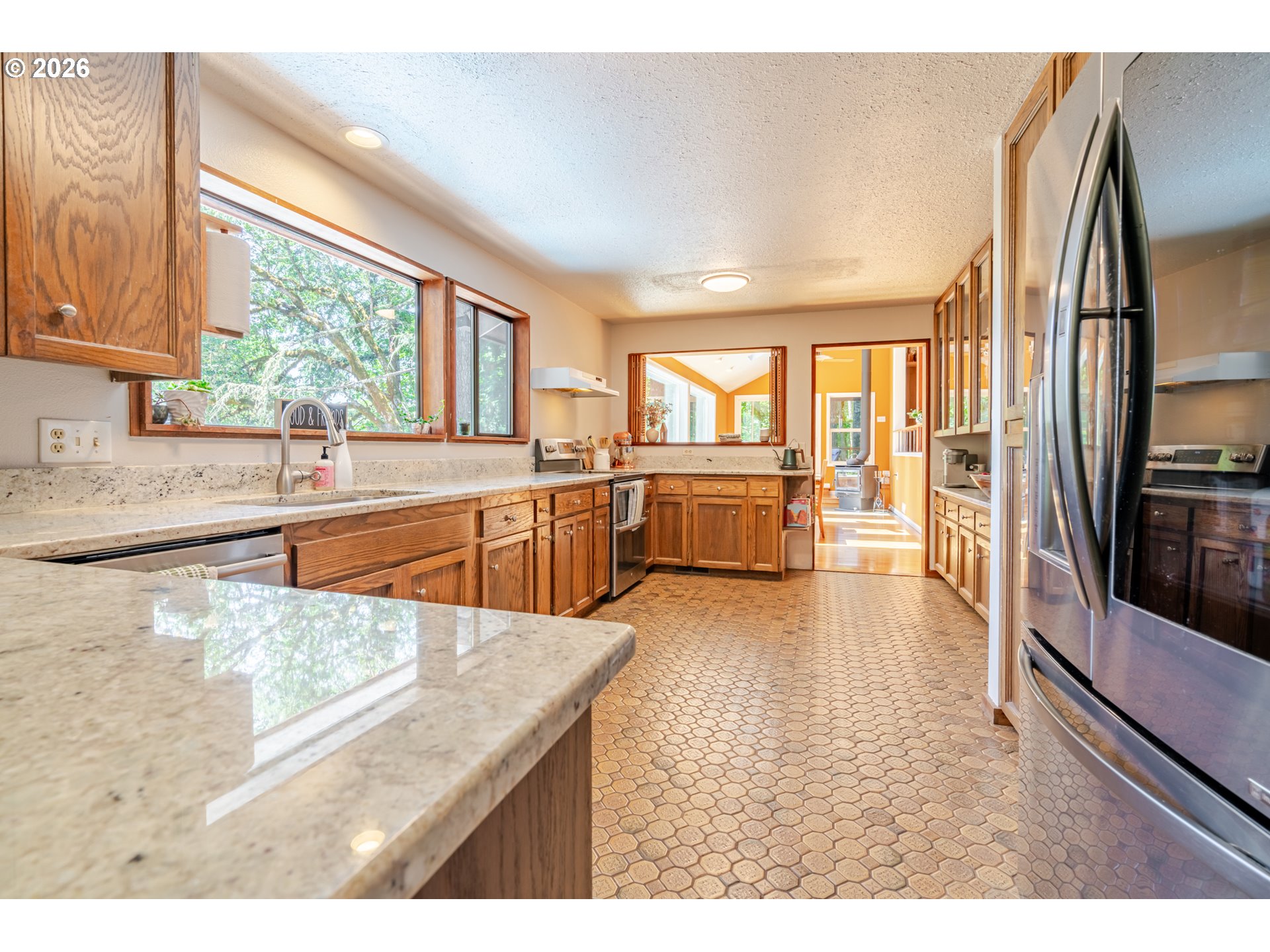 1622 Northwest Ribier Place Corvallis, OR 97330 - Photo 14 of 48 a kitchen with stainless steel appliances granite countertop a refrigerator a stove and a sink with large window