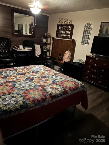 a bedroom with a bed and teddy bear on bed