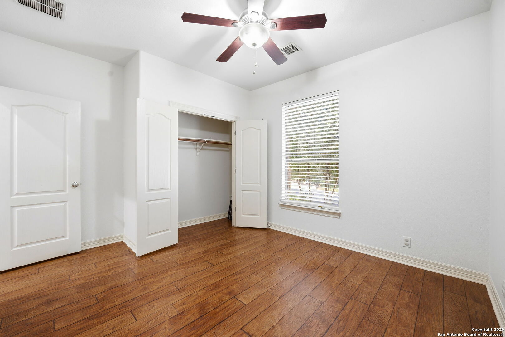 410 Heather Ridge San Antonio, TX 78260 - Photo 38 of 43 a view of an empty room with wooden floor and a window