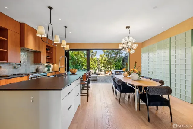a kitchen with stainless steel appliances granite countertop a sink a stove and a wooden floors