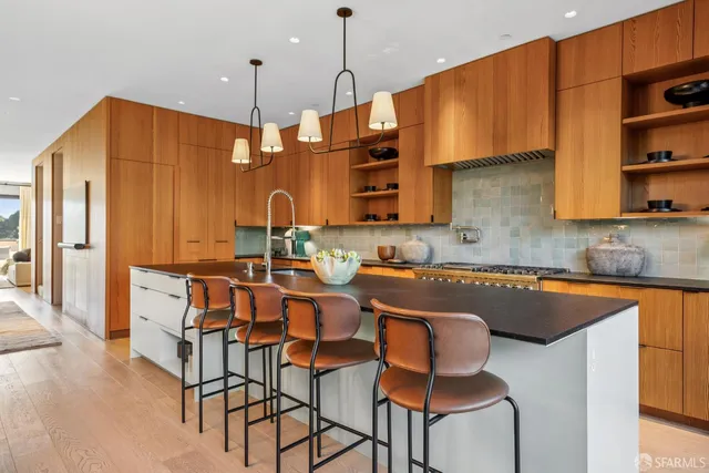 a kitchen with stainless steel appliances granite countertop a sink a stove a refrigerator and island