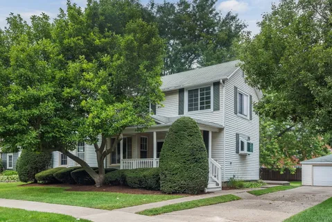 a front view of a house with a yard and trees