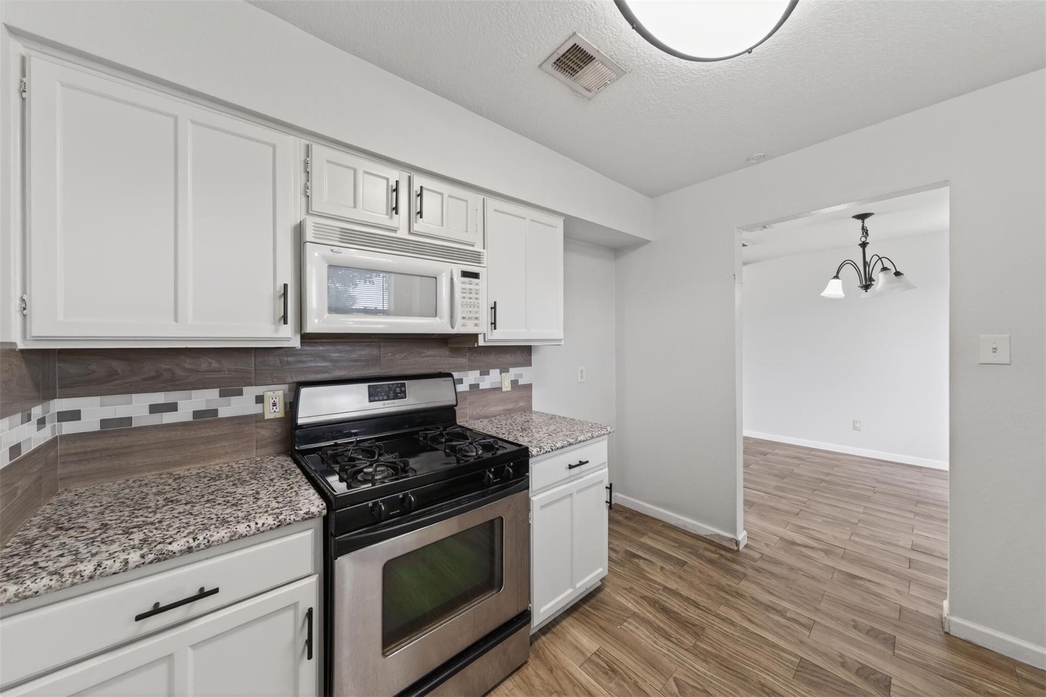 17002 Dew Drop Lane Houston, TX 77095 - Photo 11 of 24 a kitchen with granite countertop cabinets stainless steel appliances and wooden floor
