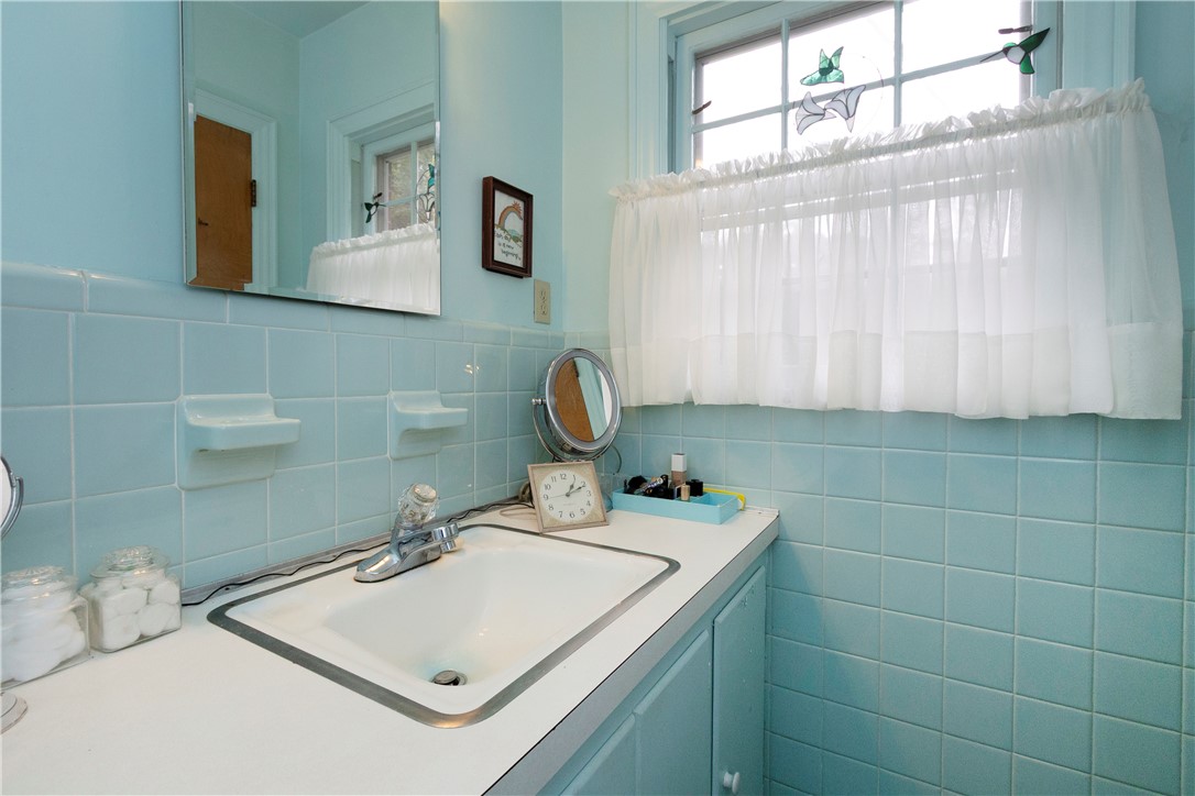 118 Blair Road Belton, SC 29627 - Photo 34 of 49 Vintage tile walls complement the integrated sink and vanity in this cozy bathroom space.