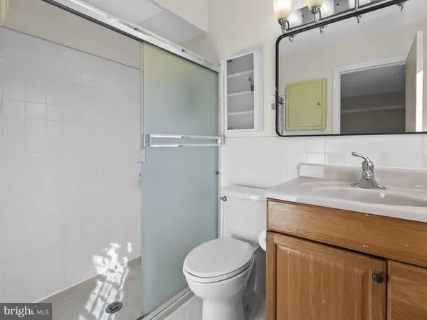a bathroom with a granite countertop toilet sink and mirror