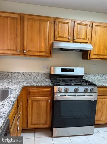a kitchen with granite countertop wood cabinets and stainless steel appliances