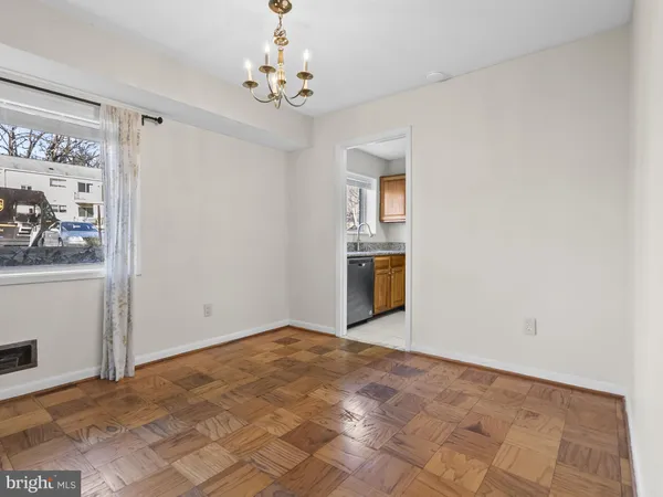 a view of a big room with wooden floor and windows