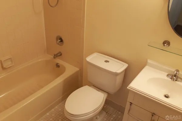 a white toilet and tub sitting next to a bathroom sink