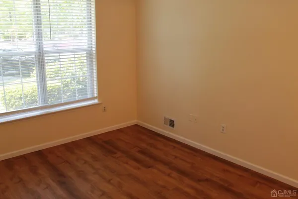 a view of a room with wooden floor and a window