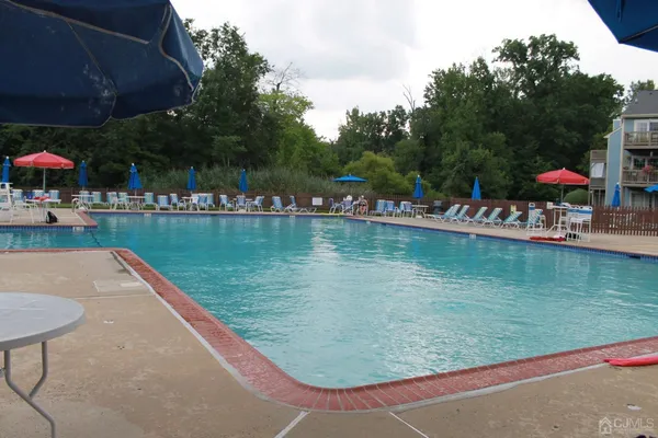 a view of swimming pool with a patio and a garden