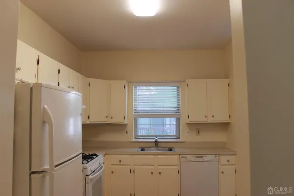 a kitchen with a refrigerator a sink and cabinets
