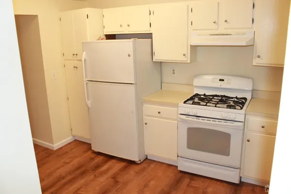 a white refrigerator freezer and a stove sitting inside of a kitchen