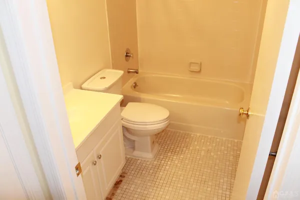 a bathroom with a granite countertop toilet and a sink