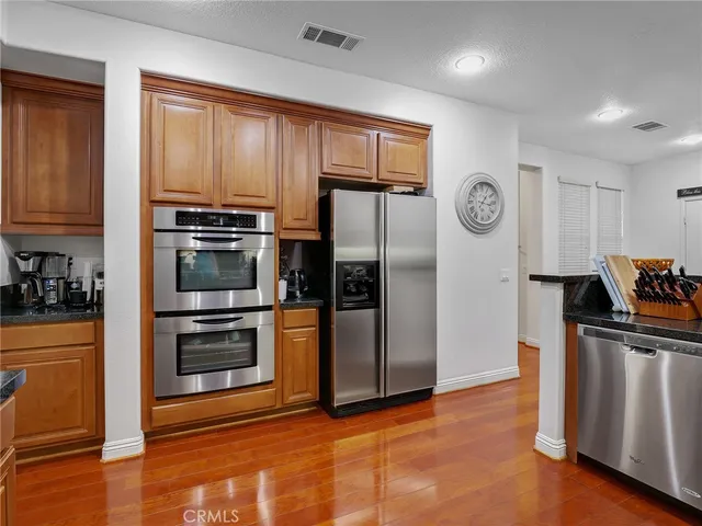 a kitchen with stainless steel appliances granite countertop a refrigerator stove and sink