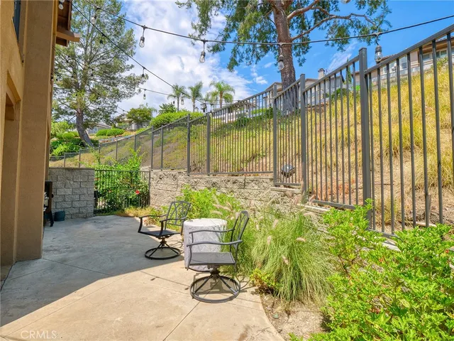 a view of a chair and table in backyard with wooden fence