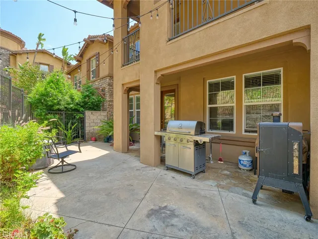 a view of a patio with a dining table and chairs and potted plants