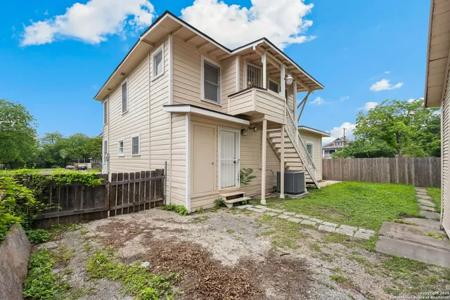 a view of a house with wooden fence