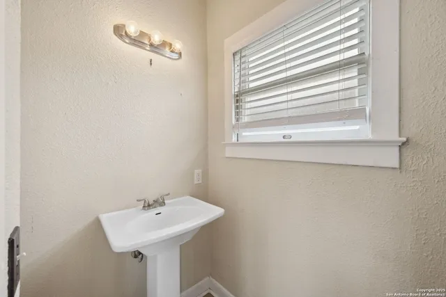 a bathroom with a sink a mirror and a window