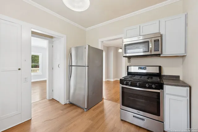 a kitchen with stainless steel appliances and granite countertop wooden cabinets