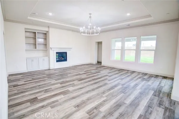 a view of an empty room with a window and fireplace