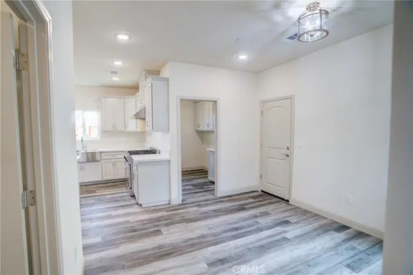 a view of a kitchen with a sink and dishwasher a refrigerator with wooden floor