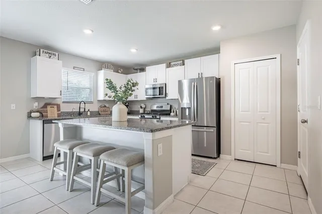 a kitchen with stainless steel appliances granite countertop a refrigerator and a stove top oven