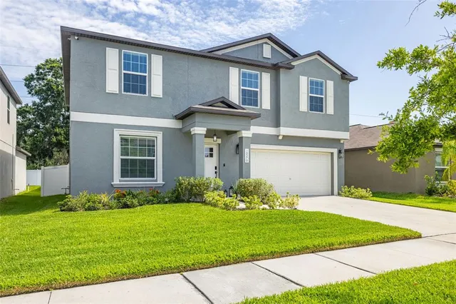 a front view of a house with a garden and plants