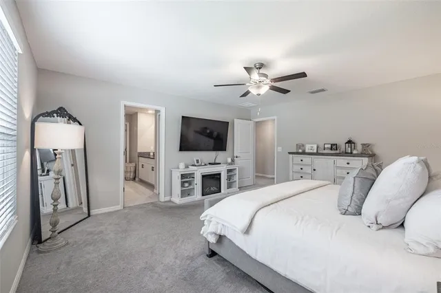 a spacious bedroom with a bed and a flat screen tv