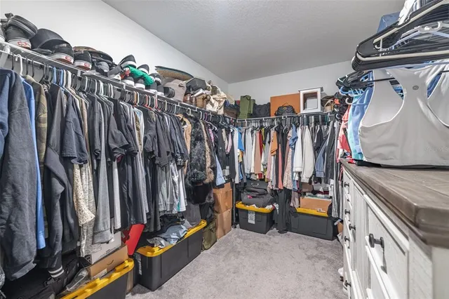 a view of walk in closet with clothes and shoes
