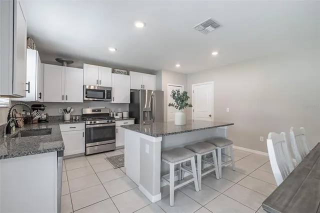 a kitchen with white cabinets and appliances