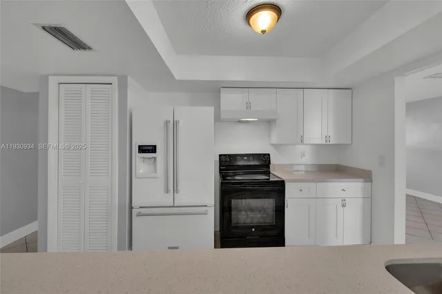 a kitchen with stainless steel appliances granite countertop a refrigerator and a stove