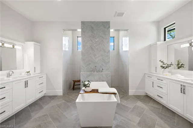 a spacious bathroom with double vanity sink a bathtub and a shower