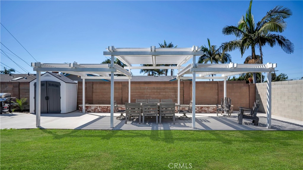 16281 Golden Gate Lane Huntington Beach, CA 92649 - Photo 21 of 22 a view of a patio with table and chairs with plants and palm trees