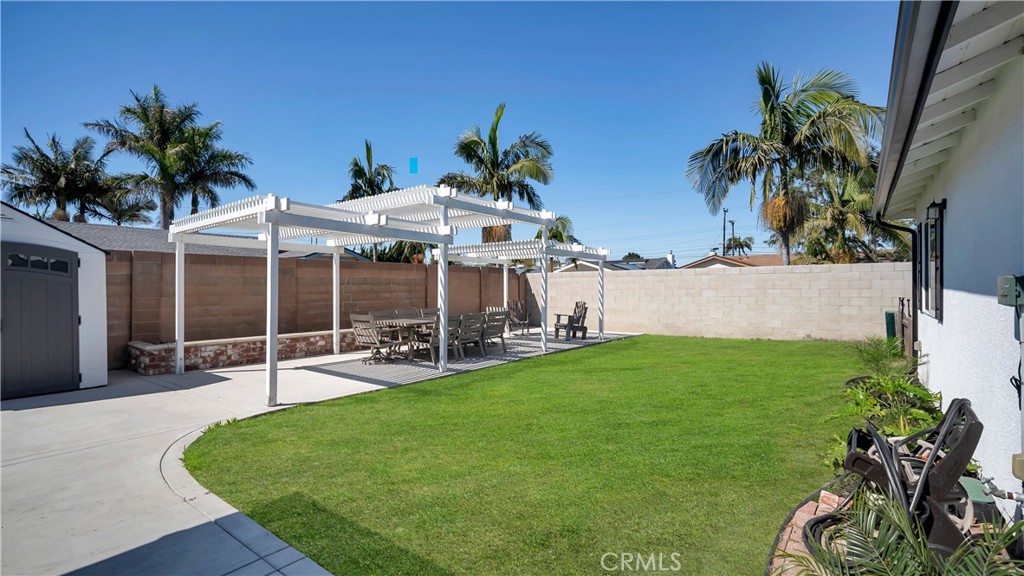 16281 Golden Gate Lane Huntington Beach, CA 92649 - Photo 22 of 22 a view of a patio with table and chairs potted plants and palm tree