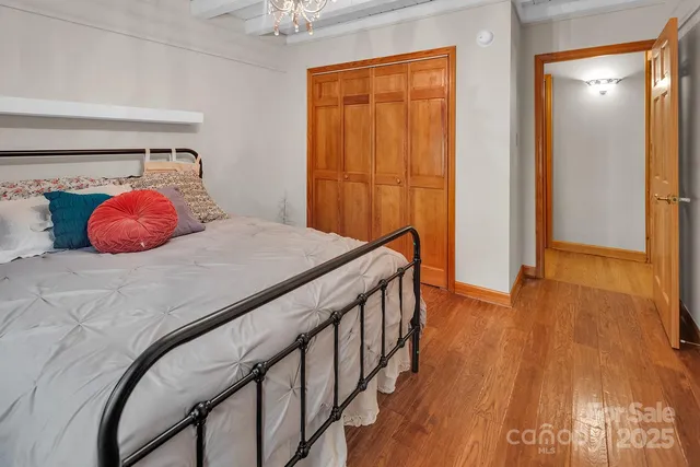 a bedroom with a bed and wooden floor