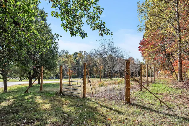 a view of a house with a yard and wooden fence