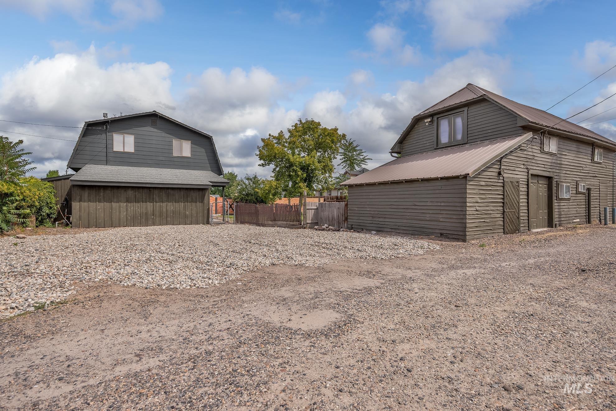 61 Southwest 4th Street Ontario, OR 97914 - Photo 36 of 42 Gravel parking area featuring two barn-style structures with vertical and horizontal wood siding