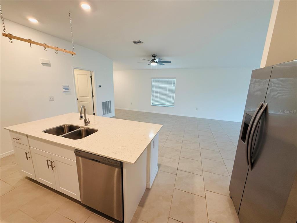 4034 San Clemente Court North Fort Myers, FL 33917 - Photo 15 of 22 a kitchen with a sink a refrigerator and white cabinets