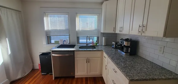a kitchen with a stove and white cabinets