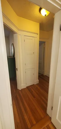 a view of a hallway with wooden floor and staircase