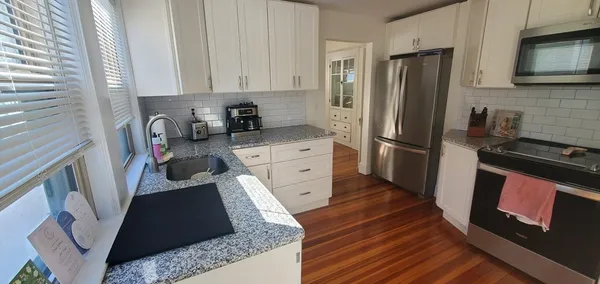 a kitchen with stainless steel appliances granite countertop a refrigerator stove and sink