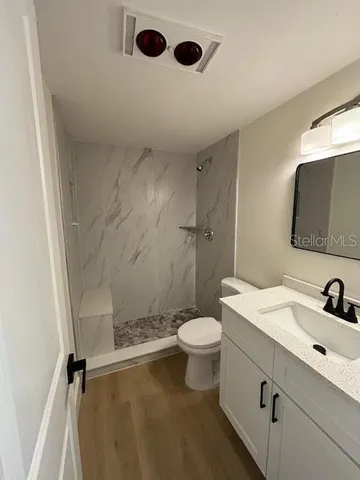 a bathroom with a sink toilet a mirror and shower