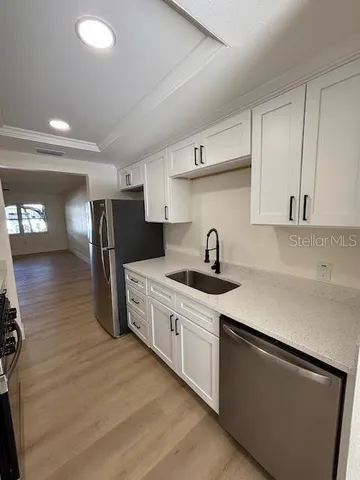 a kitchen with stainless steel appliances granite countertop a sink a stove and a refrigerator