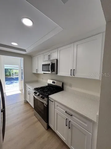 a kitchen with white cabinets and appliances