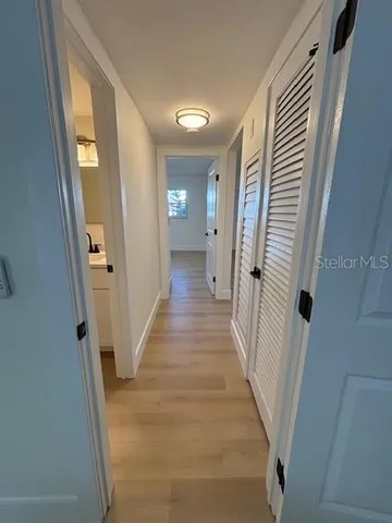 a view of a hallway with wooden floor and staircase