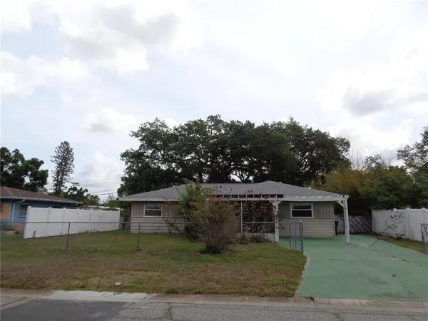 a view of a yard in front of a house with large trees