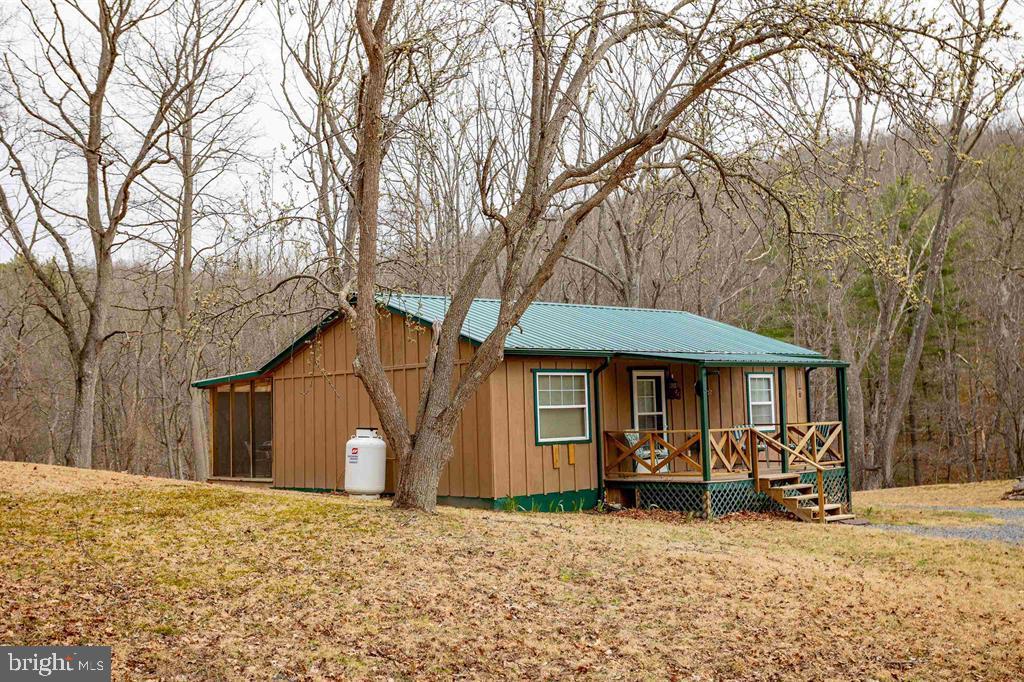 49 Mount Top Road Baker, WV 26801 - Photo 32 of 34 a view of a house with a large tree and wooden fence