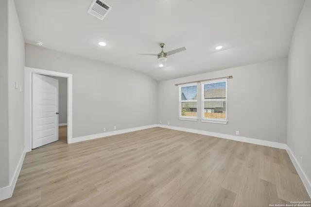 wooden floor in an empty room with a kitchen